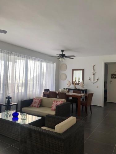 a living room with a couch and a table at Vista Mare Ocean View Top Floor Condo, Samana in Santa Bárbara de Samaná