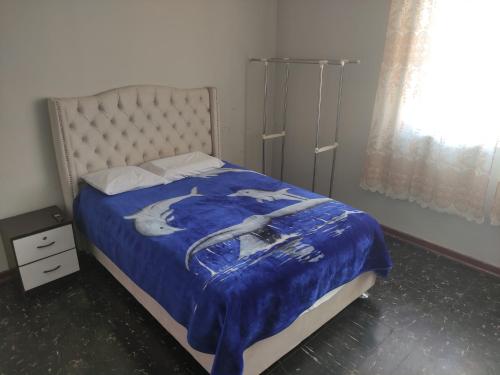 1 dormitorio con 1 cama con manta azul en Residencial 200 Casas, en Tacna