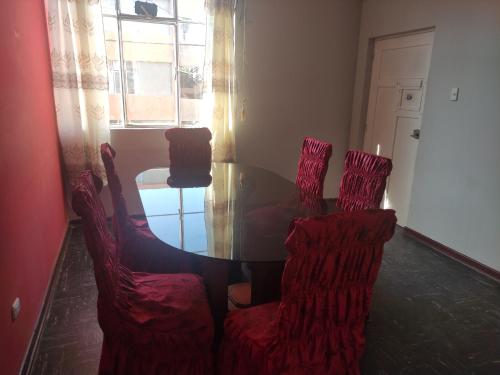 a dining room with a table and four chairs at Residencial 200 Casas in Tacna