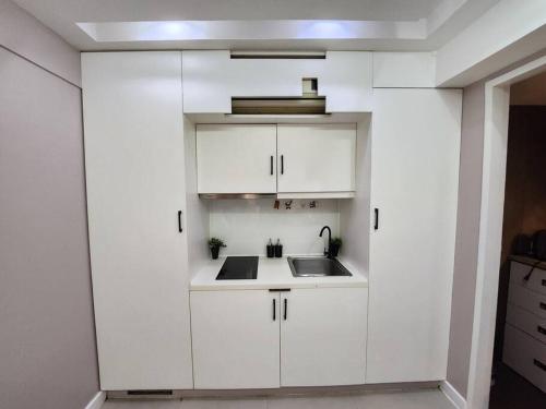 a kitchen with white cabinets and a sink at Enjoy BGC Sunset and Golf Course View 2 BR Loft with 100mbps Internet Connection in Manila