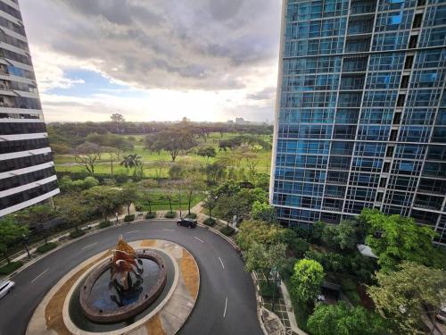 a statue in the middle of a road between two buildings at Enjoy BGC Sunset and Golf Course View 2 BR Loft with 100mbps Internet Connection in Manila