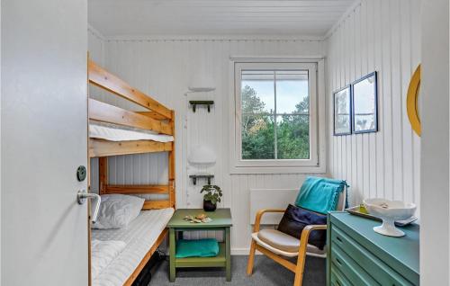 BjerregårdにあるAmazing Home In Hvide Sande With 3 Bedrooms And Wifiの二段ベッド1組、デスクが備わる小さな客室です。