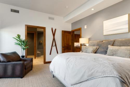 サウス・レイクタホにあるUltimate Luxury Residence with Extras Galore across from Heavenly Village & Gondola - Zalanta Resortのベッドルーム(大型ベッド1台、椅子付)