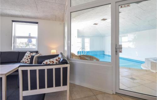 ブラーバンドにあるNice Home In Blvand With 5 Bedrooms, Sauna And Indoor Swimming Poolのリビングルーム(ガラスの引き戸からプールを望む)
