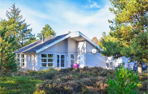 a small house on a hill with trees at Holiday Home Småfolksvej Rømø Iv in Bolilmark