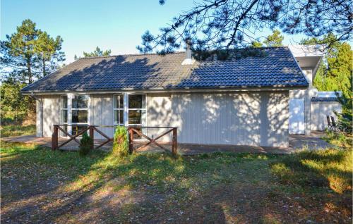 a small white house with a porch in front of it at Holiday Home Småfolksvej Rømø Iv in Bolilmark