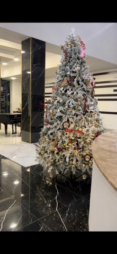 a christmas tree in a room with a piano at Tsaghkadzor Alvina complex in Tsaghkadzor