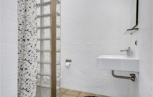 a white bathroom with a sink and a shower at Nice Home In Ebeltoft With 5 Bedrooms, Wifi And Indoor Swimming Pool in Ebeltoft