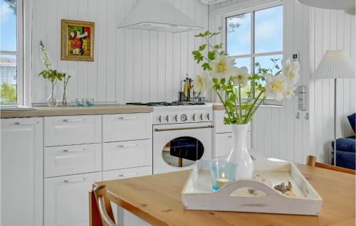 a kitchen with a table with a vase of flowers at Gorgeous Home In Brenderup Fyn With Wifi in Vedelshave