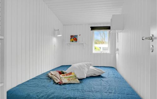 1 dormitorio con cama con sábanas azules y ventana en Gorgeous Home In Brenderup Fyn With Wifi, en Vedelshave