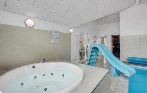 a bathroom with a tub and a blue slide at Cozy Home In Nordborg With Kitchen in Nordborg