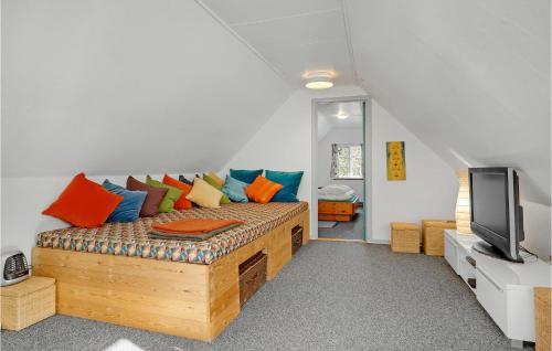 a room with a couch with colorful pillows and a television at Gæstehuset in Fjellerup