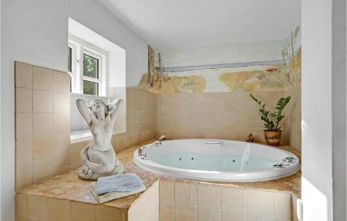 a bathroom with a tub with a statue of a woman at Gæstehuset in Fjellerup