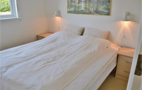a white bed in a room with two night stands at Tisvildelund in Vejby