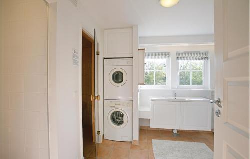 a bathroom with a washing machine and a sink at Tisvildelund in Vejby