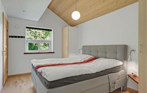 HelberskovにあるStunning Home In Hadsund With 5 Bedrooms, Sauna And Wifiの窓付きの部屋にベッド付きのベッドルーム1室があります。