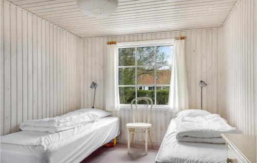NeksøにあるStunning Home In Nex With Wifiのベッド2台と窓が備わる客室です。
