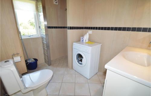 uma casa de banho com uma máquina de lavar roupa e um WC em Amazing Home In Lundby With Kitchen em Lundby Stationsby