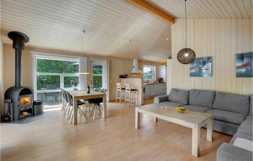 a living room with a couch and a table and a fireplace at Holiday Home Lyngvej Vig Ii in Vig
