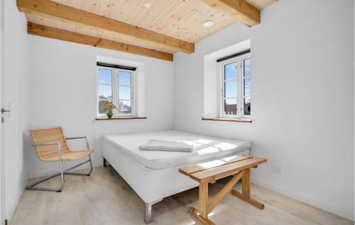 a white room with a bed and a chair at 3 Bedroom Beautiful Home In Havndal in Havndal