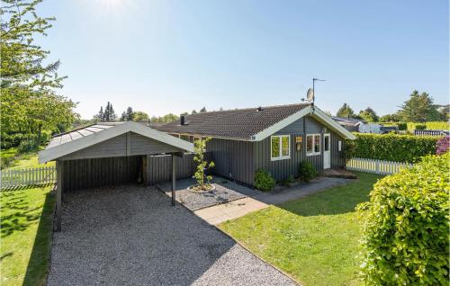 a small house with a garage in a yard at Pet Friendly Home In Bogø By With Sauna in Bogø By
