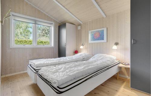 a large bed in a room with a window at Stunning Home In Bog By With Sauna in Bogø By