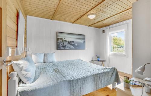 ボアディングボーにあるBeautiful Home In Vordingborg With 1 Bedrooms And Wifiの木製の天井が特徴のベッドルーム1室(大型ベッド1台付)