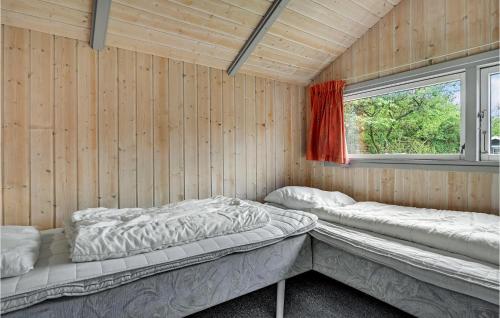 エーベルトフトにあるBeautiful Home In Ebeltoft With 4 Bedrooms And Saunaのベッド2台と窓が備わる客室です。