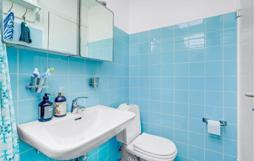 ホルベックにあるGorgeous Home In Holbk With Kitchenの青いタイル張りのバスルーム(洗面台、トイレ付)