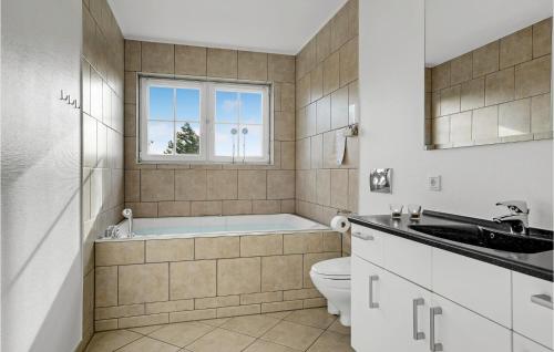 a bathroom with a tub and a toilet and a sink at Nice Apartment In Bogense With Wifi in Bogense