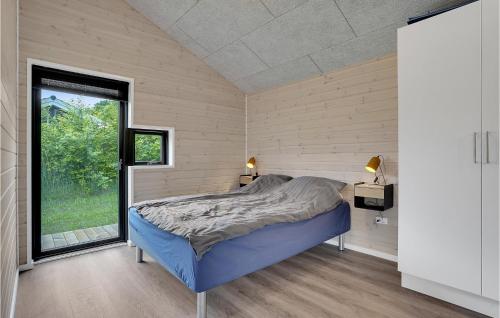 ein Schlafzimmer mit einem Bett und einem großen Fenster in der Unterkunft 3 Bedroom Gorgeous Home In Glesborg in Fjellerup Strand
