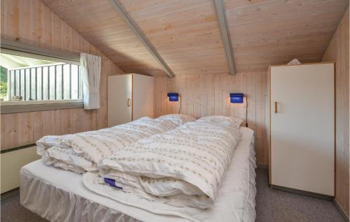 Cama grande en habitación con paredes de madera en Gorgeous Home In Fan With Wifi, en Fanø