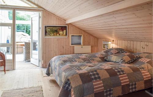 - une chambre avec un lit dans une pièce dotée de murs en bois dans l'établissement Cozy Home In Gilleleje With Wifi, à Gilleleje