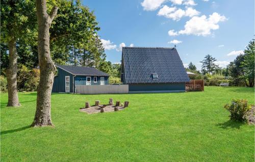 a park with a tree and a house at Two-Bedroom Holiday Home In Rudkobing in Spodsbjerg