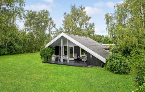 a small house with a pitched roof on a lawn at 2 Bedroom Awesome Home In Nakskov in Nakskov
