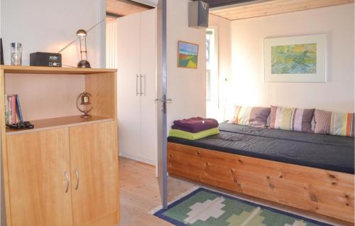 a bedroom with a bed and a wooden cabinet at Lærken in Vejers Strand