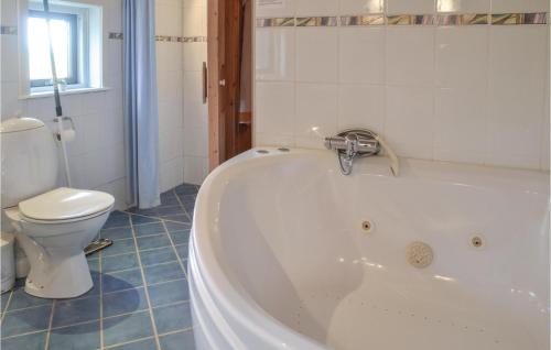 a bathroom with a tub and a toilet at Lærken in Vejers Strand