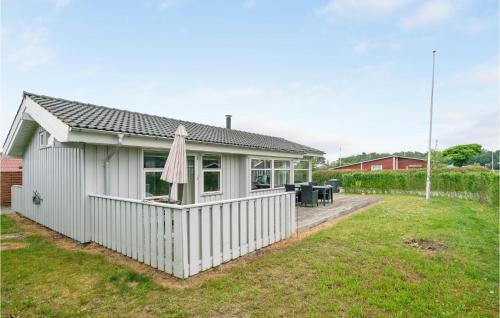 a white house with a fence in a yard at Birkely in Nyborg
