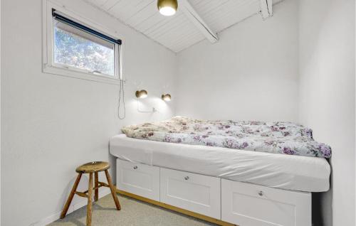 Posto letto in camera con finestra e sgabello. di Amazing Home In Holbk With Wifi a Holbæk