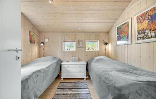 two beds in a room with wooden walls at Cozy Home In Eg With Kitchen in Egå