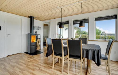 a dining room with a table and chairs and a fireplace at Amazing Home In Bogense With Sauna in Bogense