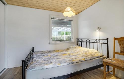 ein Schlafzimmer mit einem Bett in einem Zimmer mit einem Fenster in der Unterkunft Amazing Home In Bogense With Sauna in Bogense