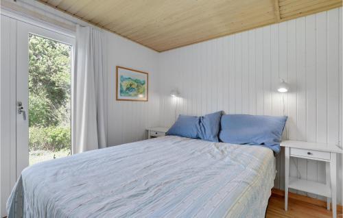 スヴァネケにあるPilaのベッドルーム1室(青い枕のベッド1台、窓付)