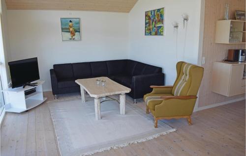 a living room with a couch and a table and a chair at Holiday Home Følfodvænget in Humble