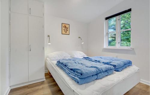 Bøtø Byにある2 Bedroom Stunning Home In Vggerlseの白いベッドルーム(青い掛け布団付きのベッド1台付)