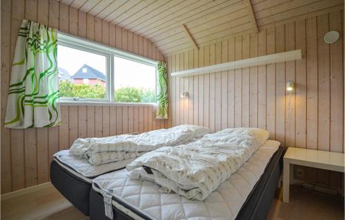 two beds in a room with a window at Nice Home In Glesborg With House Sea View in Bønnerup Strand