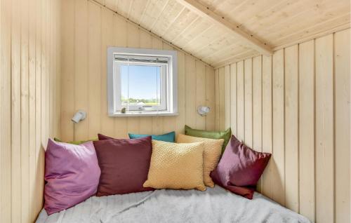 ノーポにあるAwesome Home In Nordborg With 3 Bedrooms, Sauna And Wifiのカラフルな枕付きのベッドが備わる客室です。