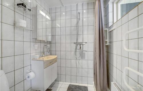 a white tiled bathroom with a sink and a shower at Pet Friendly Home In Vinderup With Sauna in Vinderup