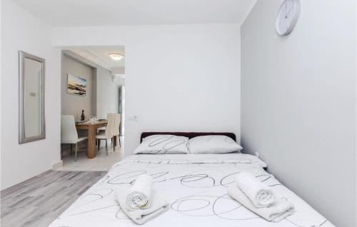Stunning Apartment In Kostrena With Kitchen في كوسترينا: غرفة نوم بيضاء مع سرير كبير مع شراشف بيضاء