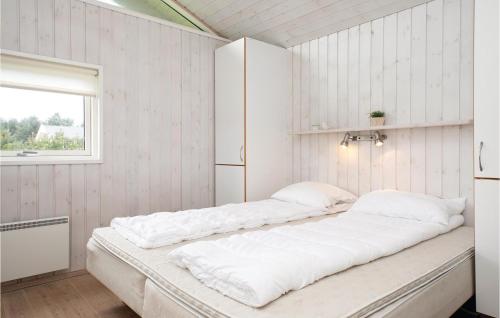 a bedroom with two beds and a window at Stunning Home In Lkken With 5 Bedrooms, Sauna And Wifi in Løkken